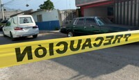 Se ven de fndo unos carros estacionados y una cinta amarilla de precaución.