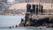 Migrantes cruzan a nado por la playa del Tarajal hacia Ceuta, donde el colapso obliga a cientos de personas a dormir en plena calle. (Archivo AP)