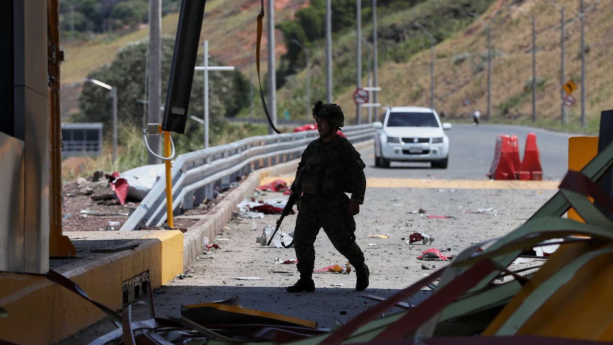 Un soldado camina por una estación de peaje de la Carretera Panamericana, dañada en una explosión.