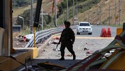 Un soldado camina por una estación de peaje de la Carretera Panamericana, dañada en una explosión.