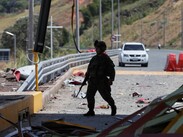 Un soldado camina por una estación de peaje de la Carretera Panamericana, dañada en una explosión.