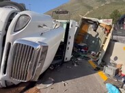 Tras la volcadura, la caja del tráiler se abrió y la carga de paquetería que transportaba quedó regada sobre la carpeta asfáltica.