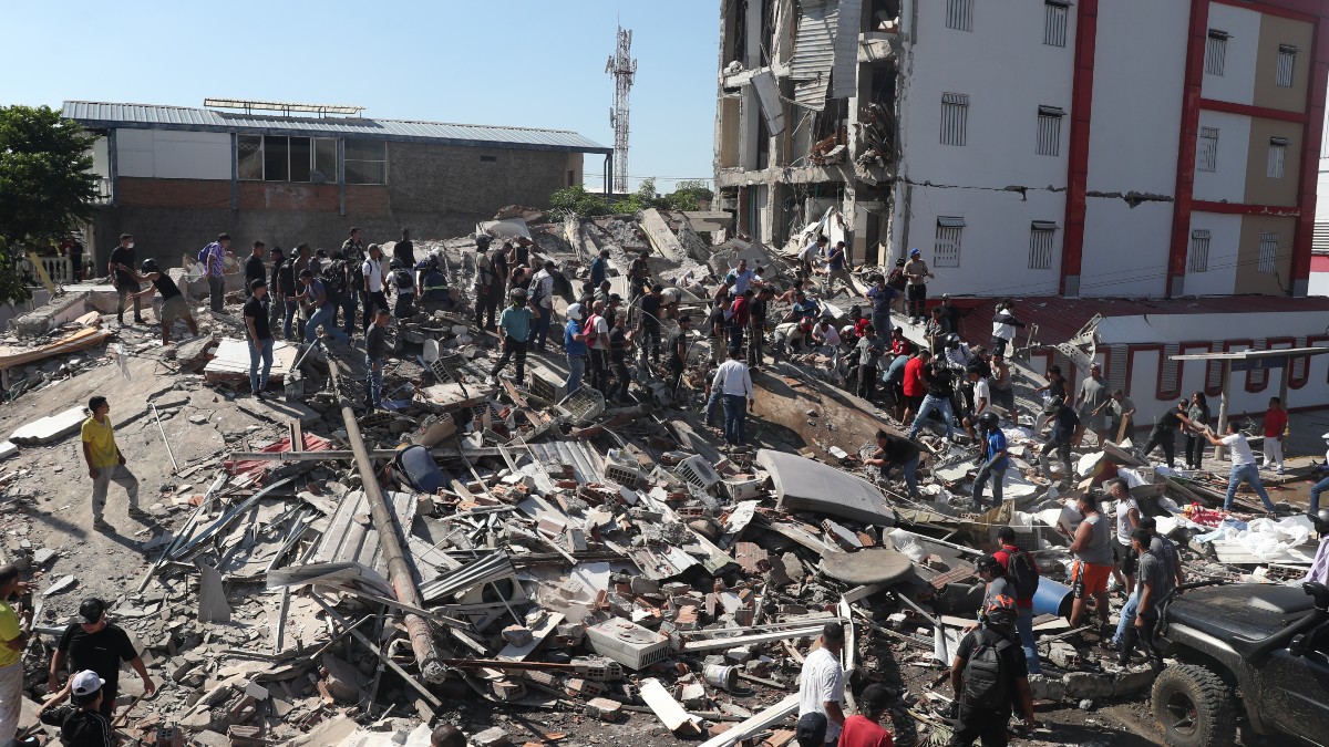 Residentes y equipos de rescate buscan entre los escombros de un edificio derrumbado tras el terremoto que azotó Cali.