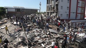 Residentes y equipos de rescate buscan entre los escombros de un edificio derrumbado tras el terremoto que azotó Cali.