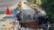 Cuerpos de emergencia laboran en la zona donde la unidad volcada quedó sobre uno de sus costados tras precipitarse desde la vía.