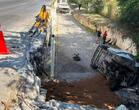 Cuerpos de emergencia laboran en la zona donde la unidad volcada quedó sobre uno de sus costados tras precipitarse desde la vía.