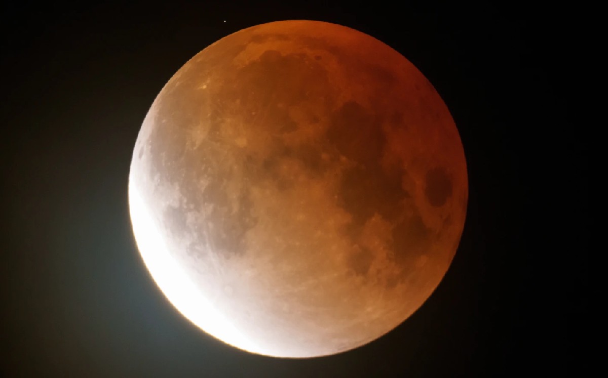 La luna de gusano brilla en color naranja mientras comienza a elevarse durante un eclipse lunar. | Foto/Ted S. Warren