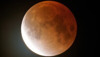 La luna de gusano brilla en color naranja mientras comienza a elevarse durante un eclipse lunar. | Foto/Ted S. Warren