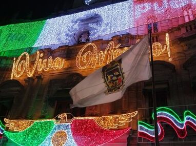 El alcalde de Puebla, Pepe Chedraui, enciende la iluminación patria frente al Palacio Municipal, rodeado de miles de familias