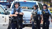 Agentes policiales apuntan sus rifles hacia una torre de apartamentos en el centro de Minneapolis, según imágenes difundidas en redes.