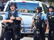 Agentes policiales apuntan sus rifles hacia una torre de apartamentos en el centro de Minneapolis, según imágenes difundidas en redes.