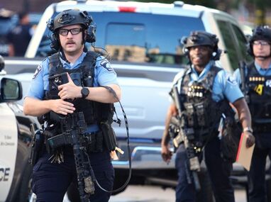Agentes policiales apuntan sus rifles hacia una torre de apartamentos en el centro de Minneapolis, según imágenes difundidas en redes.