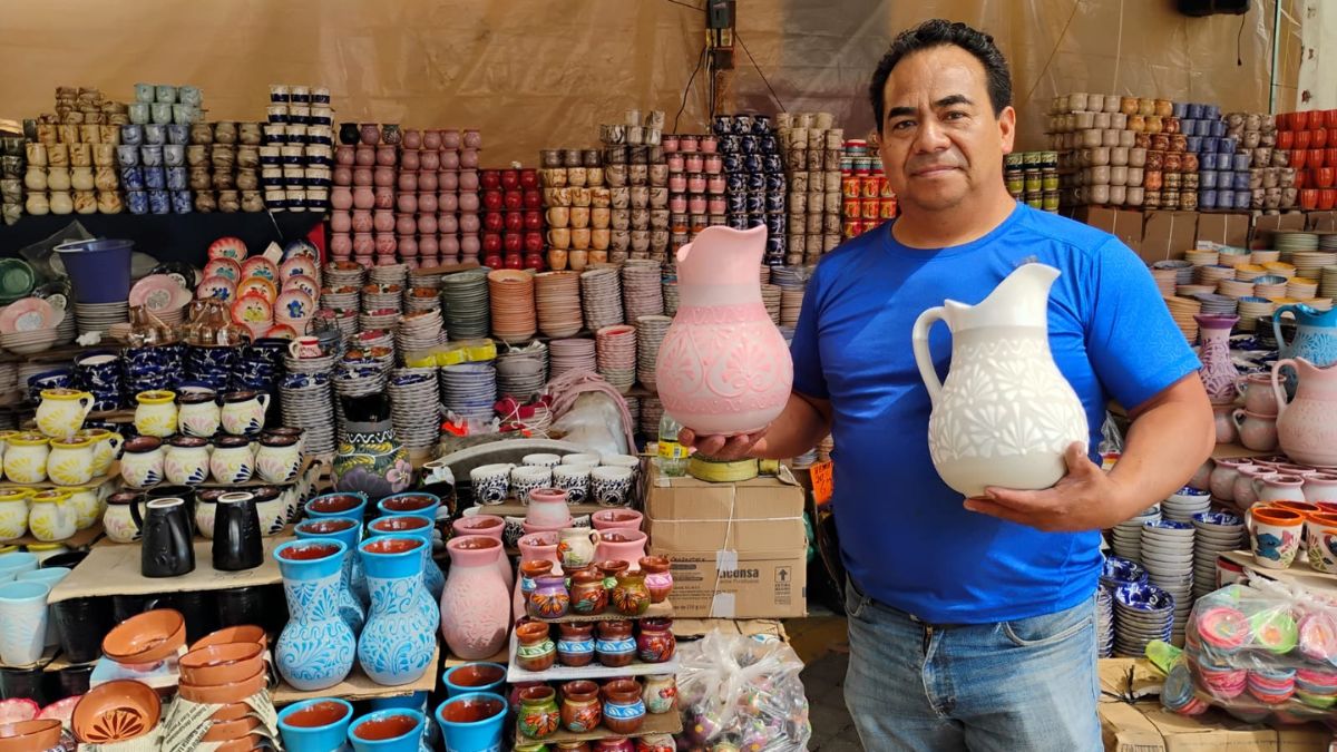 El maestro don Darío Medina, representante de la tercera generación de Alfarería El Medina, sostiene unas jarras de barro pintadas a mano
