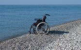 Silla de ruedas a la orilla del mar / Shutterstock