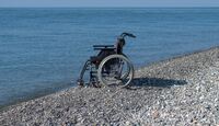 Silla de ruedas a la orilla del mar / Shutterstock