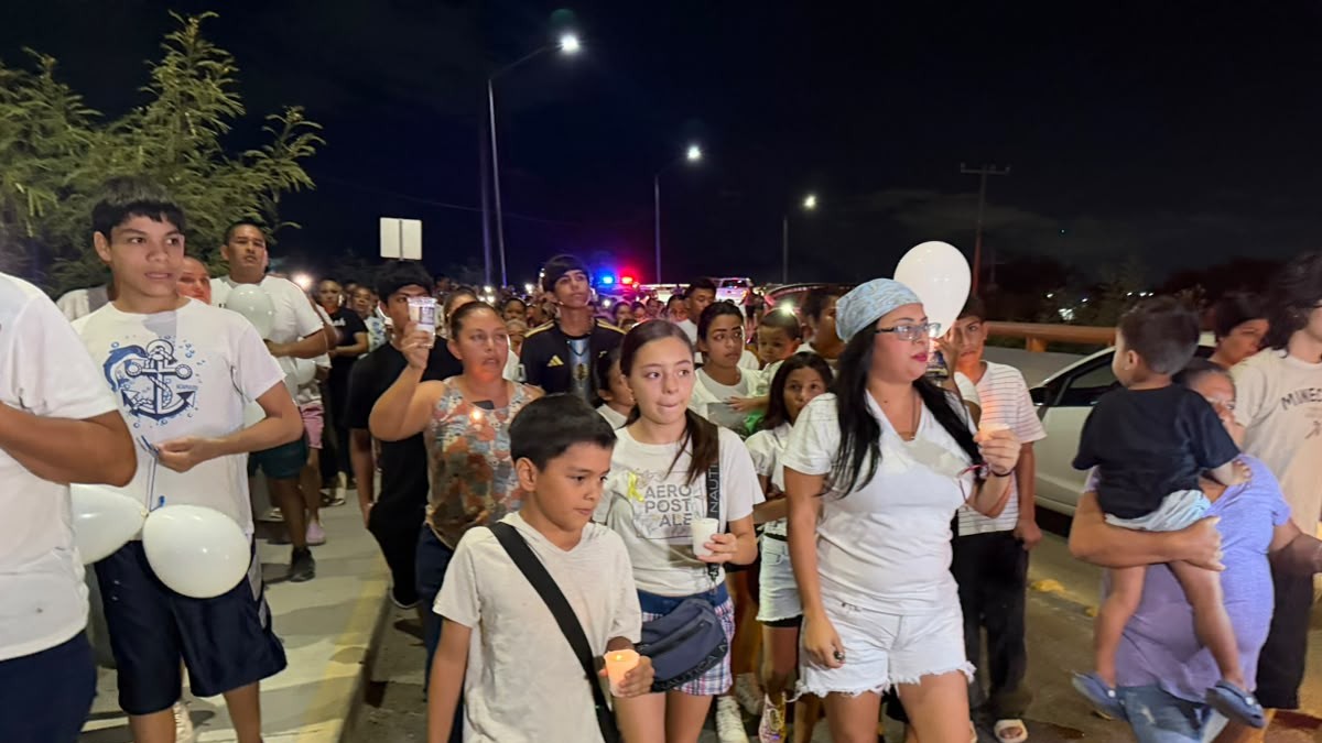 Asisten de blanco, portando globos y pancartas sobre la avenida Paseo del Mirador.