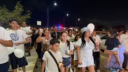 Asisten de blanco, portando globos y pancartas sobre la avenida Paseo del Mirador.
