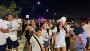 Asisten de blanco, portando globos y pancartas sobre la avenida Paseo del Mirador.