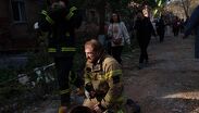Un rescatista se sienta en el piso junto a un edificio residencial destruido en un ataque con misiles rusos, en Pryluky, Ucrania/ AP