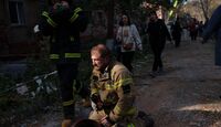 Un rescatista se sienta en el piso junto a un edificio residencial destruido en un ataque con misiles rusos, en Pryluky, Ucrania/ AP