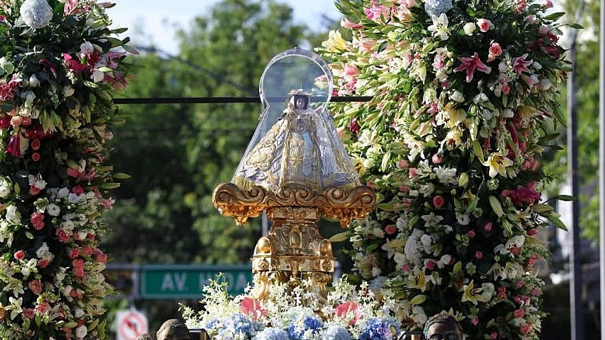 La imagen de la Virgen es llevada en un carruaje floreado.